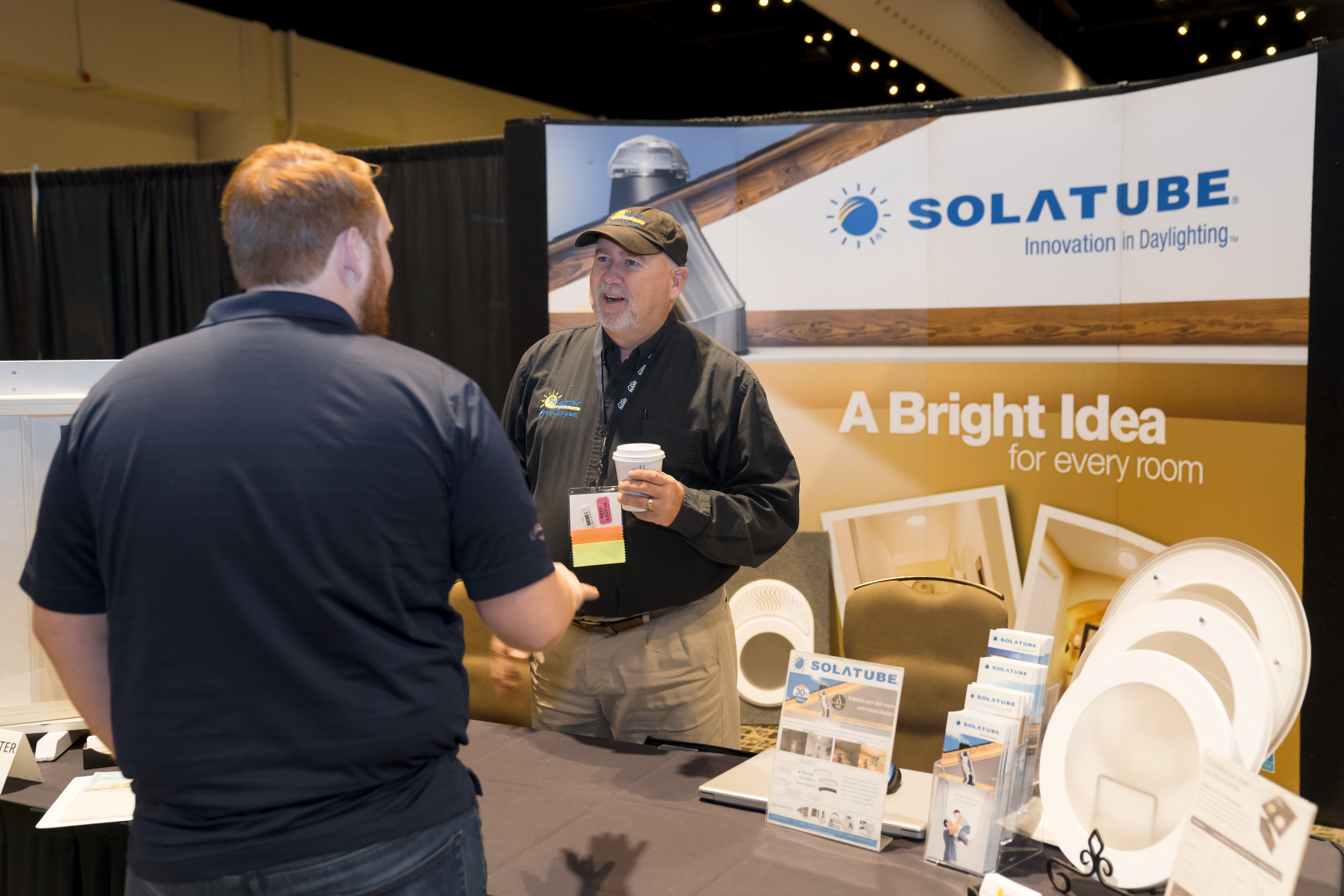 Exhibitor walking an attendee through a product