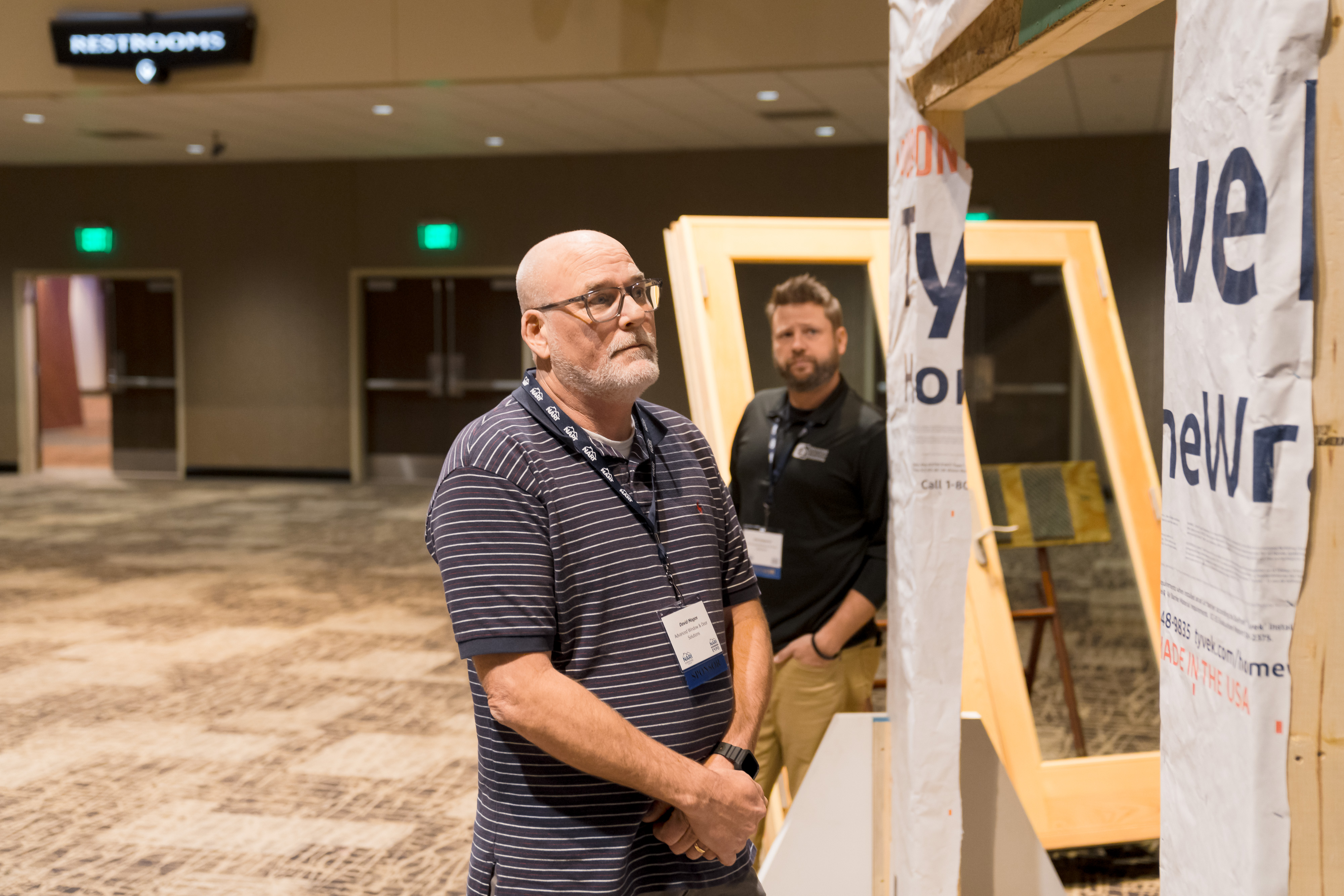 Attendee studying a full-scale wall and window installation demo
